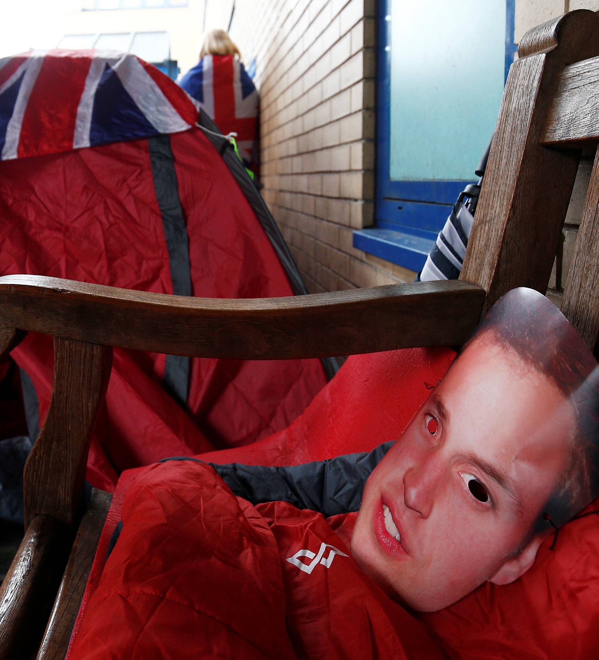 A cardboard Prince William mask is seen next to a tent belonging to fans of Britain's royal family who are camped out outside the hospital where Catherine, the Duchess of Cambridge, is due to give birth, in London