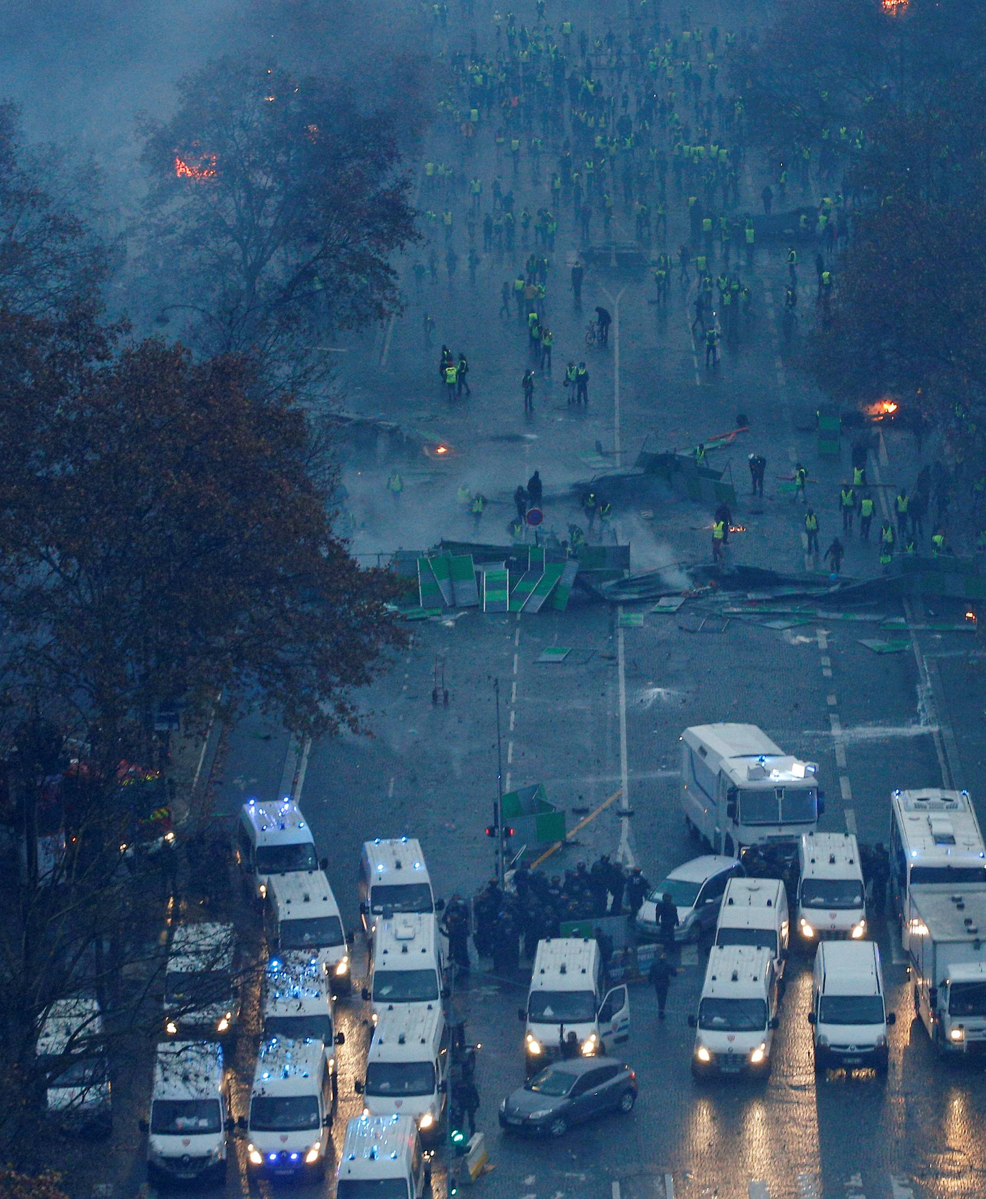 A view shows a barricade with police forces and protesters wearing yellow vests, a symbol of a French drivers' protest against higher diesel taxes, during clashes as part of a demonstration near the Place de l'Etoile in Paris