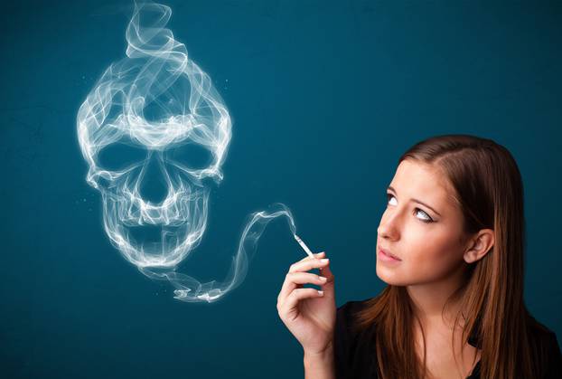 Young woman smoking dangerous cigarette with toxic skull smoke 