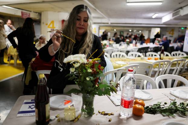 Israelis hold a Passover Seder in an underground parking garage used as a public bomb shelter, in Tel Aviv
