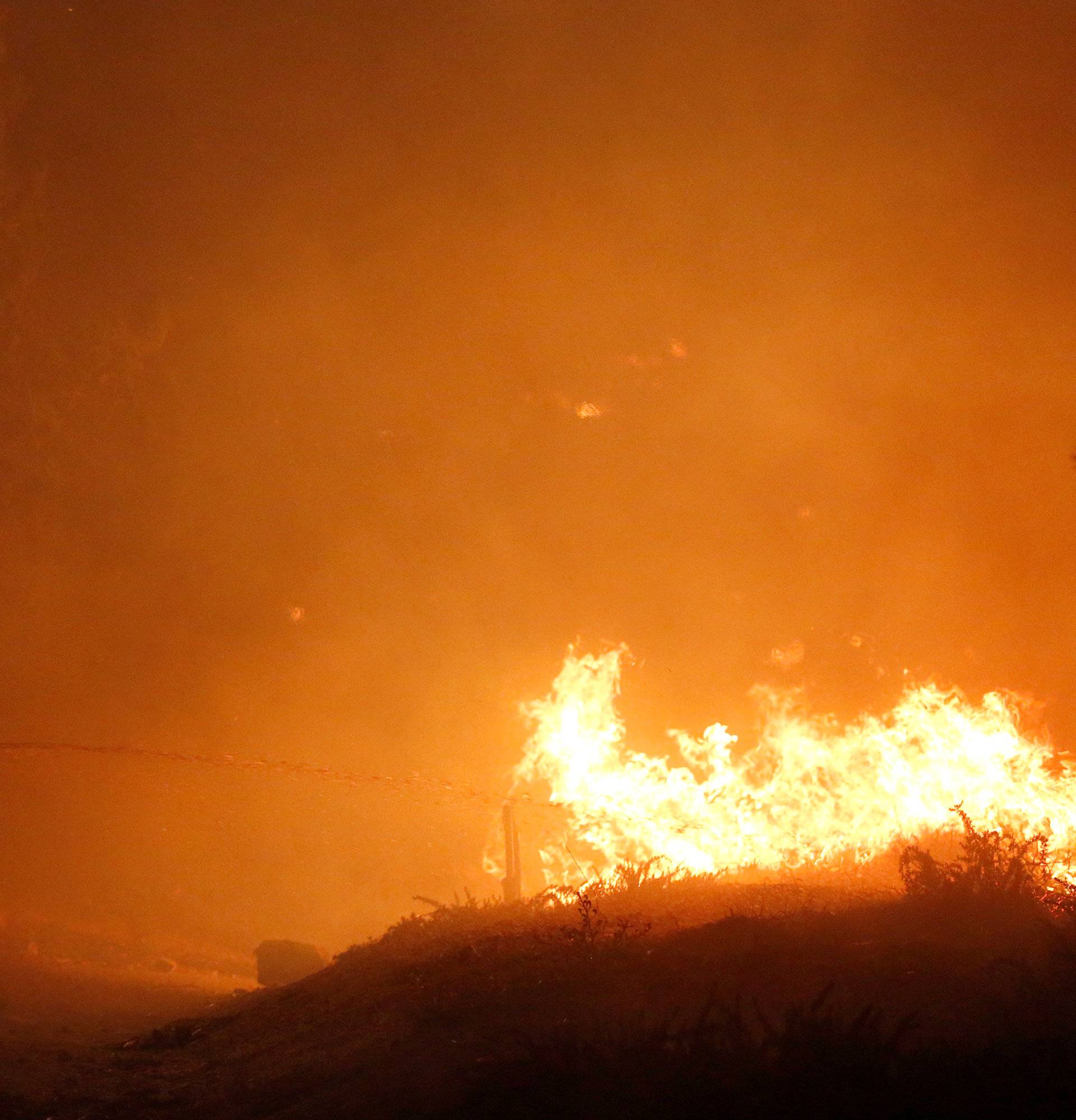 A firefighter puts out a spot fire during the Creek Fire in Sylmar, California
