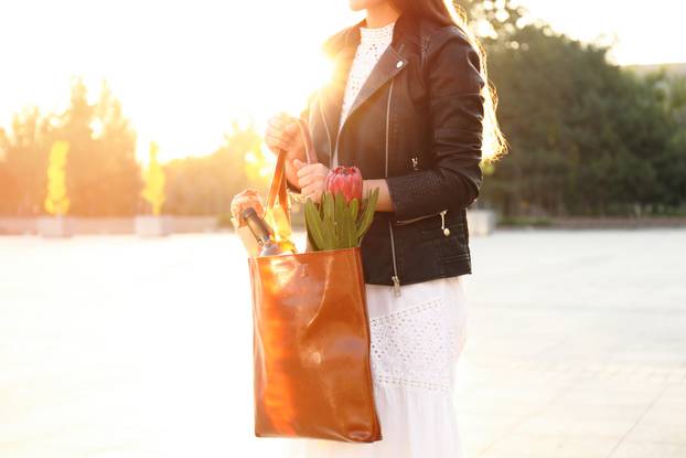 Woman with leather shopper bag on city street, closeup