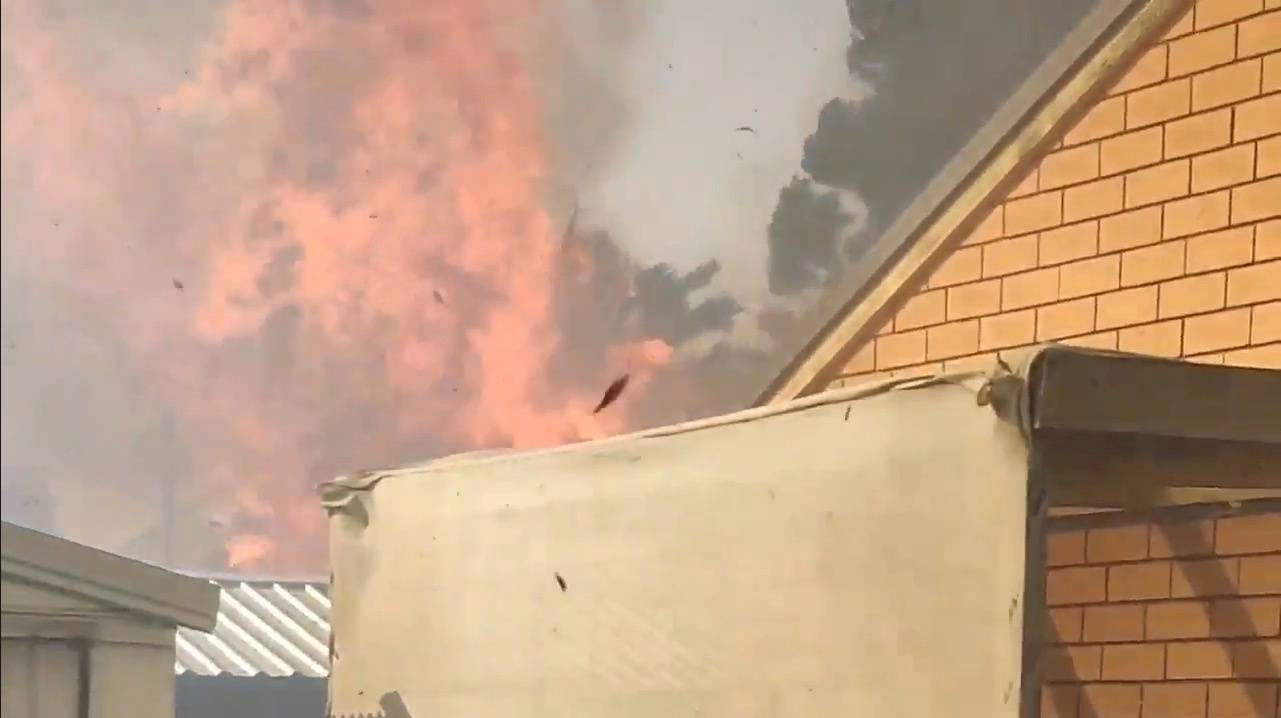 Social media video grab shows a fire blazing behind a house in Paradise City