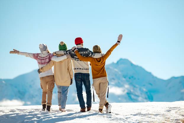 Four,Happy,Friends,Are,Standing,And,Embracing,Against,Snow,Capped