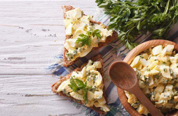 toasts and egg salad with herbs horizontal top view