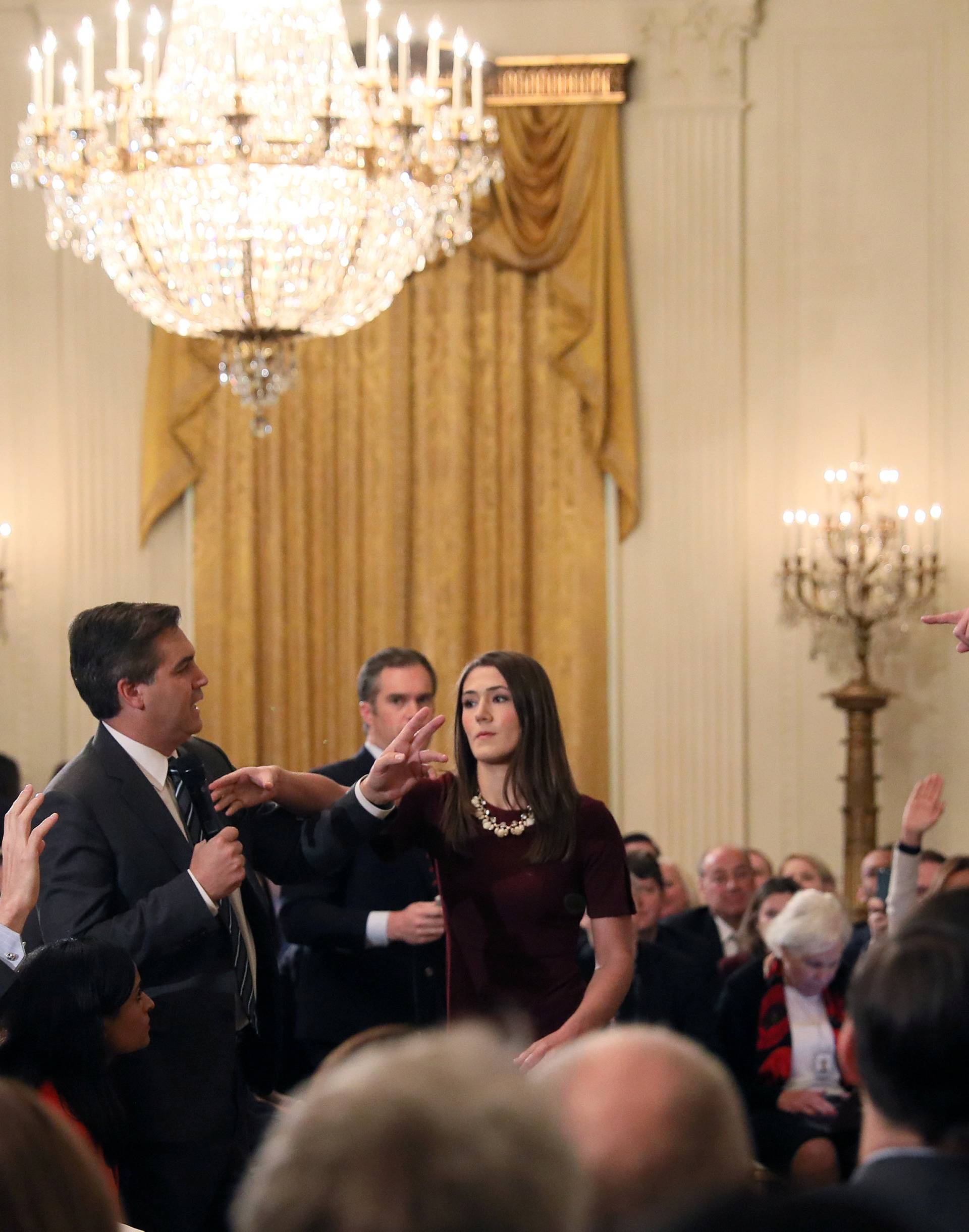 A White House staff member reaches for the microphone held by CNN's Jim Acosta as he questions U.S. President Donald Trump during a news conference in Washington