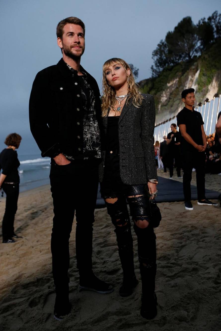 Miley Cyrus and Liam Hemsworth look on at the Saint Laurent Menâs Spring/Summer 2020 fashion show at Paradise Cove beach in Malibu