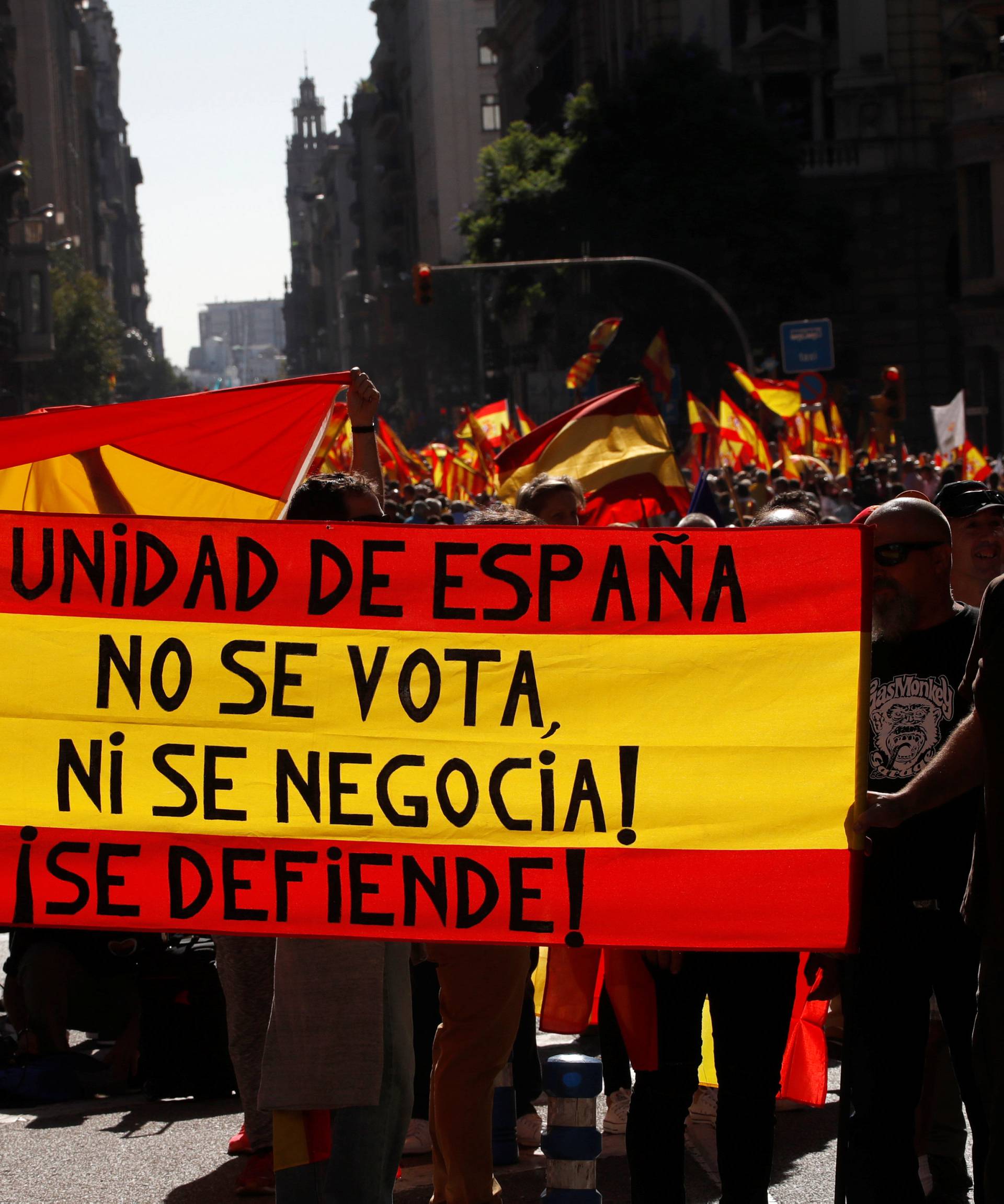People hold a Spanish flag which reads "The unity of Spain can not be voted on or negotiated, it must be defended" during a pro-union demonstration organised by the Catalan Civil Society organisation in Barcelona