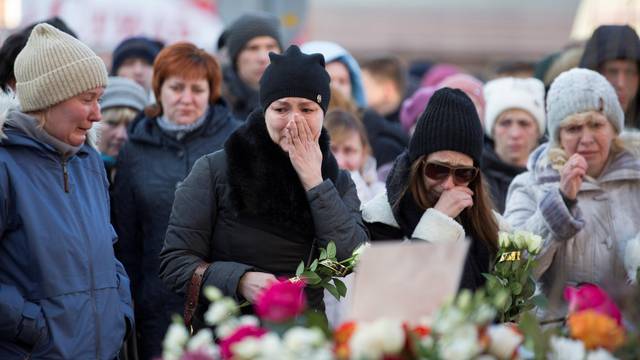 People mourn the victims of a shopping mall fire at a makeshift memorial in the Siberian city of Kemerovo