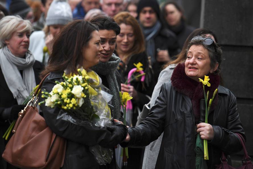 Schoolfriends bring yellow flowers to represent sunshine as they queue up to view Cranberries singer Dolores O'Riordan's coffin during her public reposal at St. Joseph's Church in Limerick