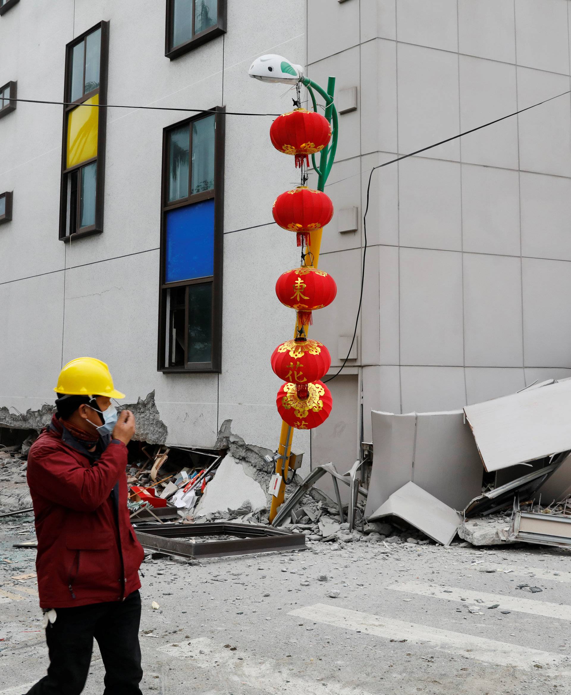 A man walks past debris outside a damaged hotel after an earthquake hit Hualien