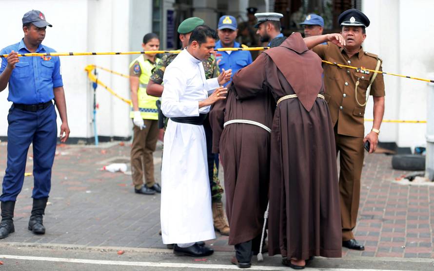 Priests walk into the St. Anthony's Shrine, Kochchikade church after an explosion in Colombo
