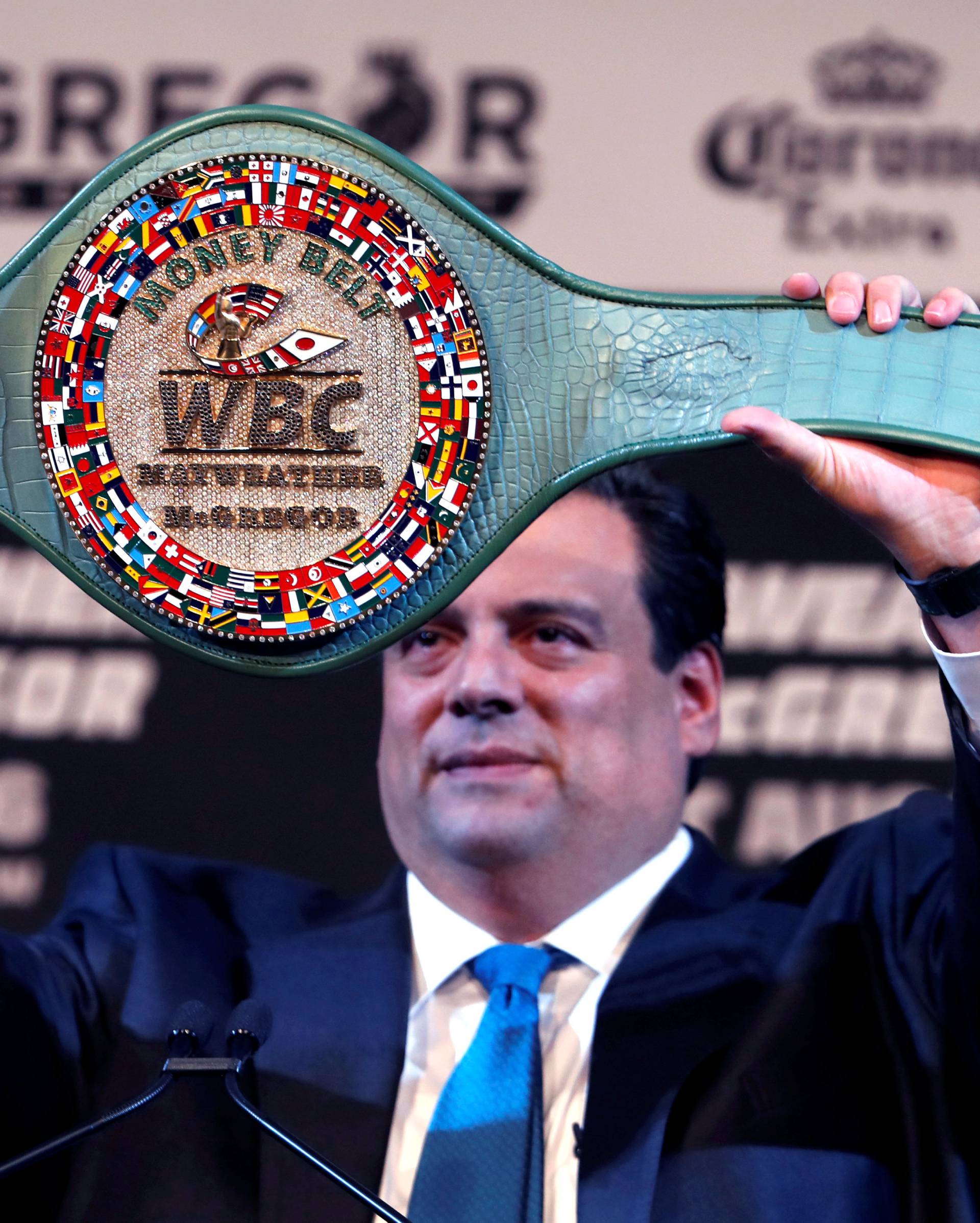 WBC President Mauricio Sulaiman holds up the WBC "Money Belt" during a news conference with undefeated boxer Floyd Mayweather Jr. of the U.S. and UFC lightweight champion Conor McGregor of Ireland in Las Vegas