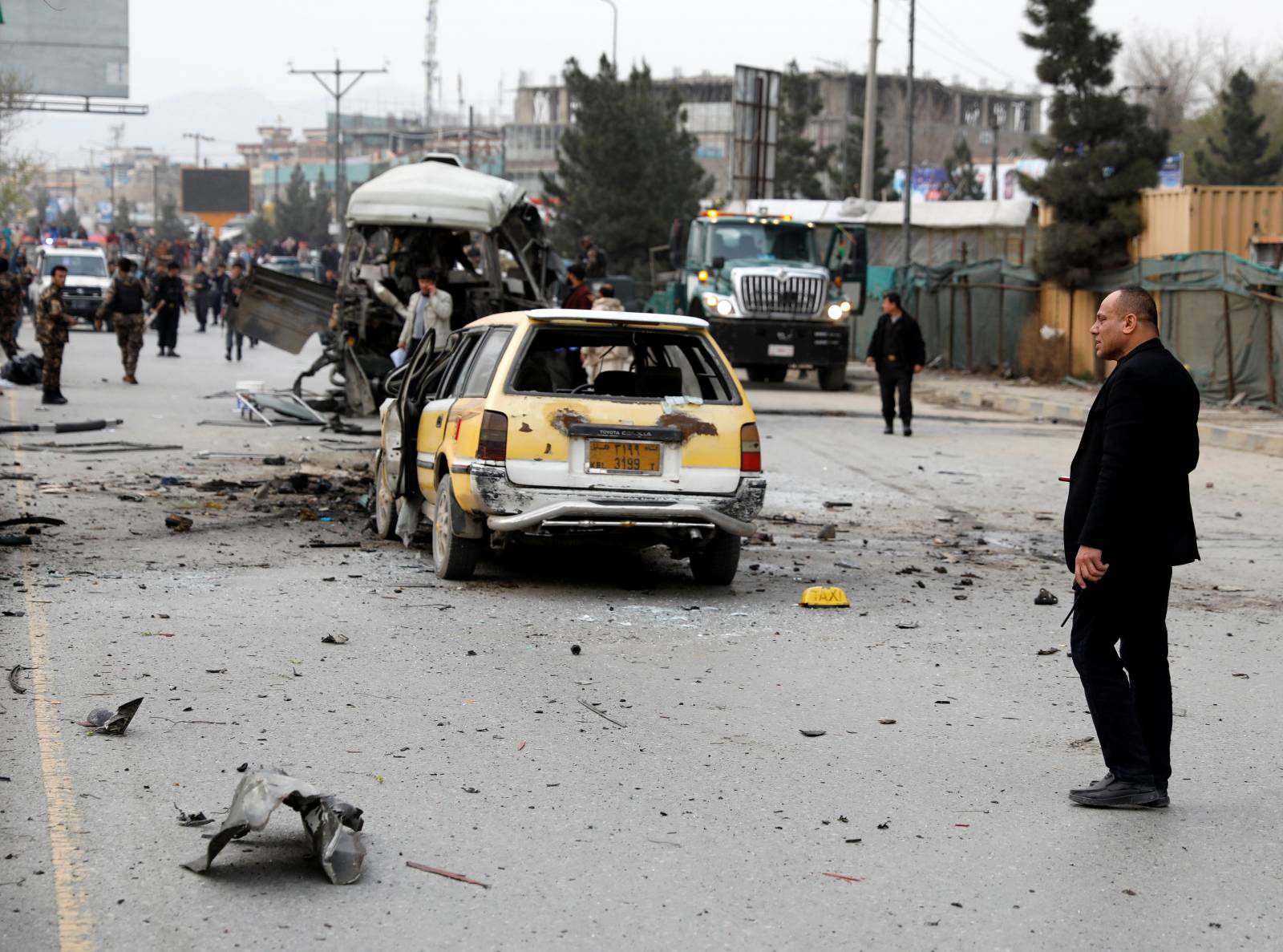 Afghan officials inspect a damaged minibus after a blast in Kabul