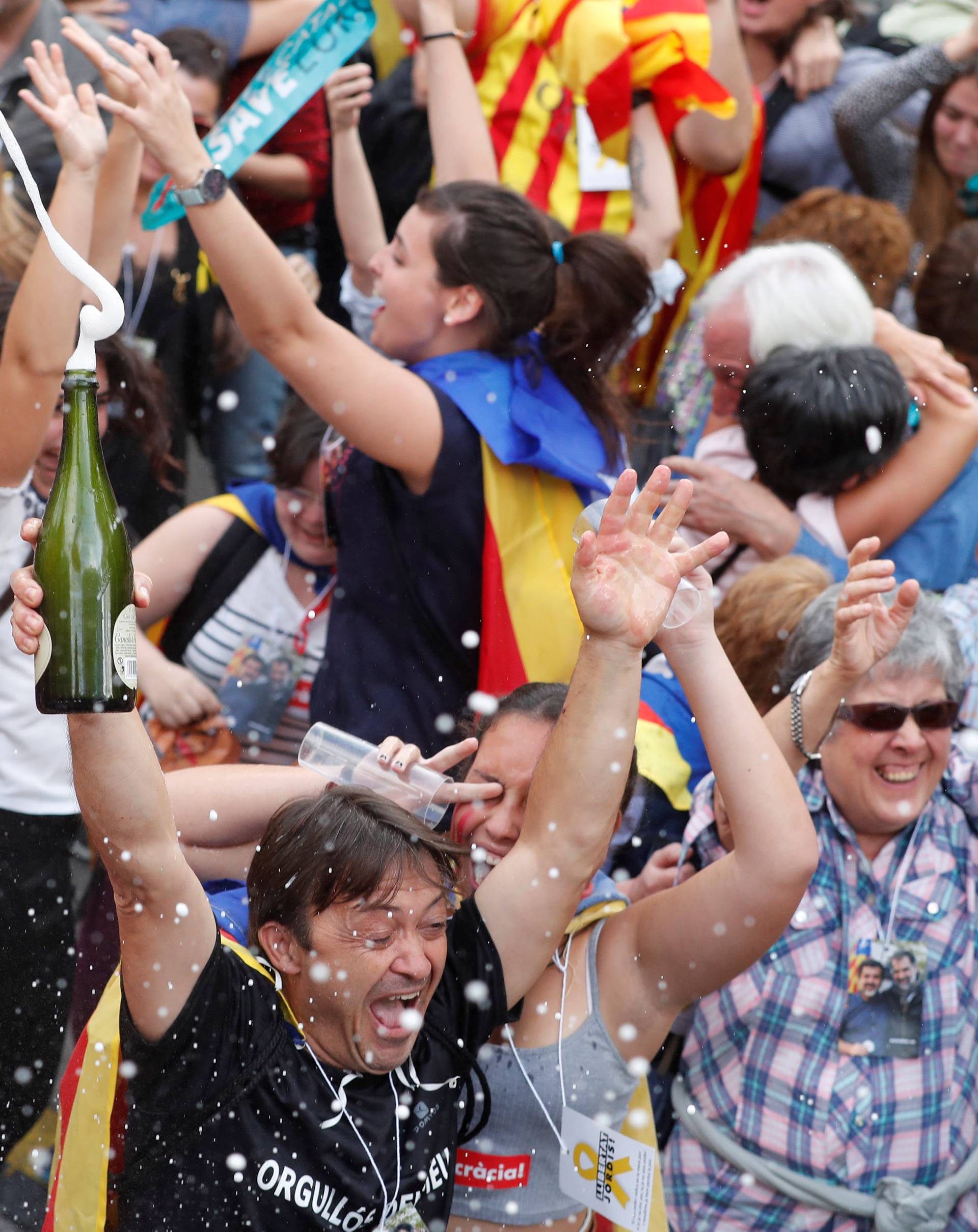 People celebrate after the Catalan regional parliament passes the vote of independence from Spain in Barcelona