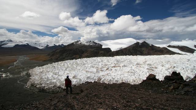 A man stands near the Jianggudiru Glacier on Geladaindong Mountain
