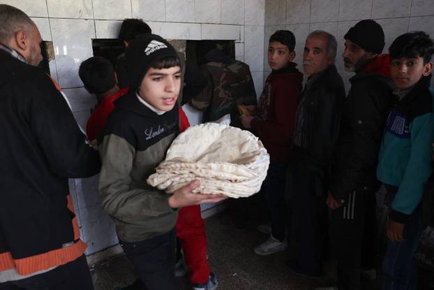 People queue to buy bread in Damascus