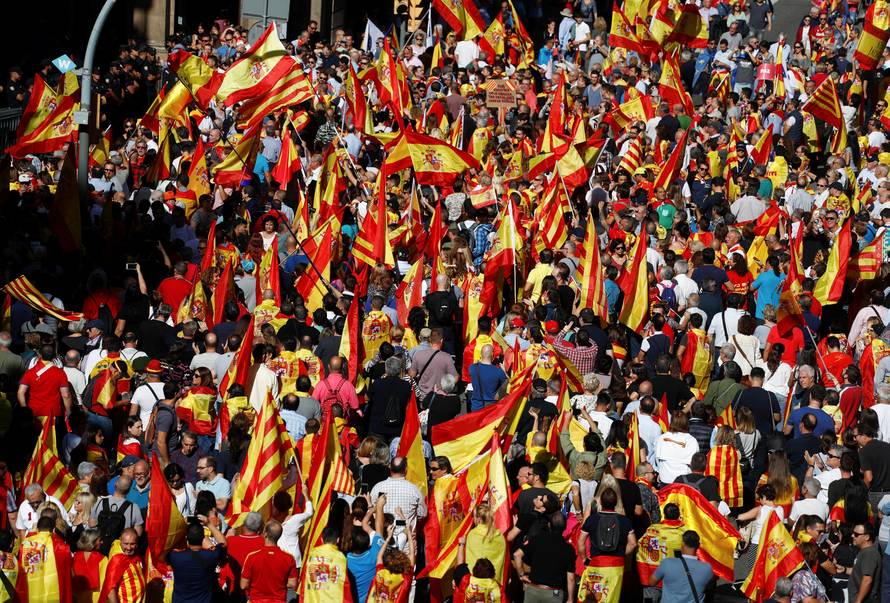 People wave Catalan and Spanish flags as they attend a pro-union demonstration organised by the Catalan Civil Society organisation in Barcelona