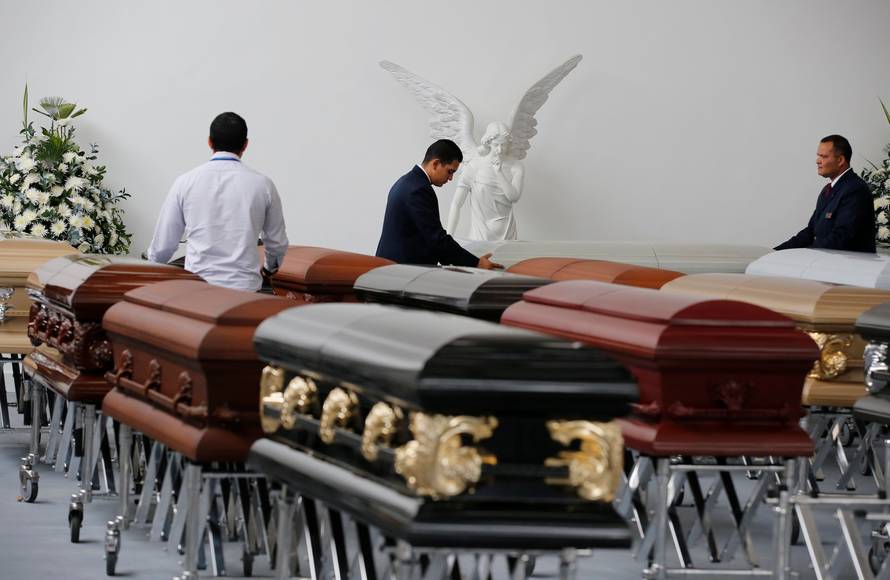 Funeral workers arrange coffins holding the remains of the victims who died in an accident of a plane that crashed into the Colombian jungle with Brazilian soccer team Chapecoense onboard, in Medellin
