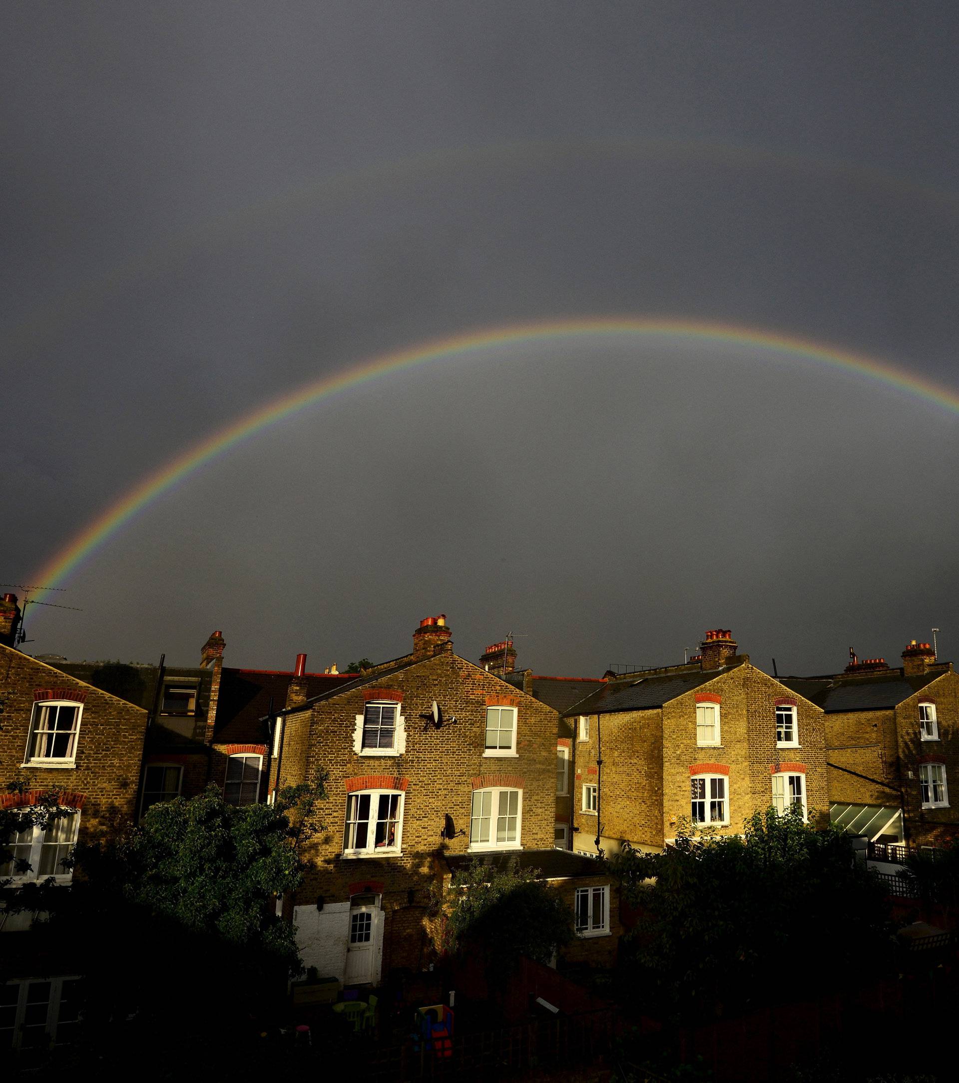 A double rainbow is seen above a row of terrace houses in Clapham, south London