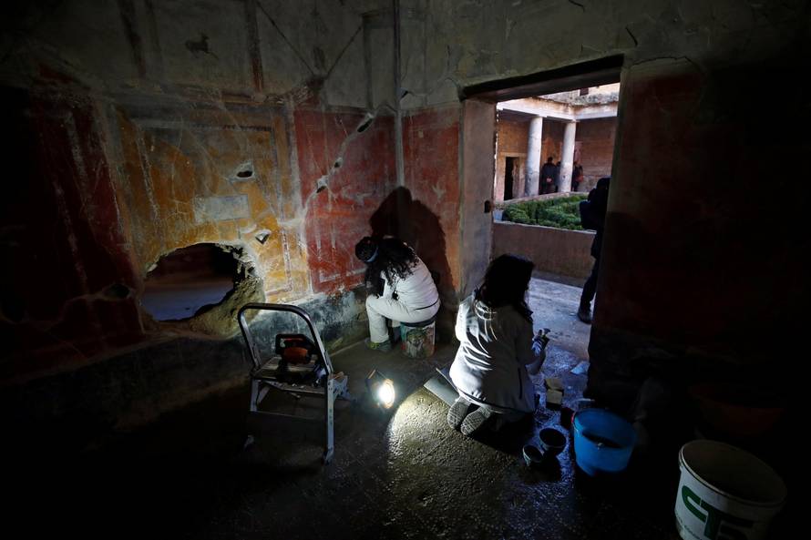 Archaeologists work on  a fresco in the House of Lovers "Casa degli Amanti\