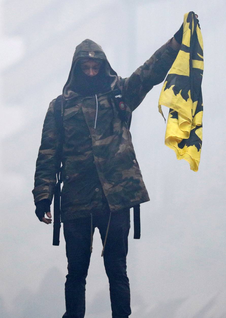 Flemish nationalist holds a Flemish flag as he attends a protest against Marrakesh Migration Pact in Brussels
