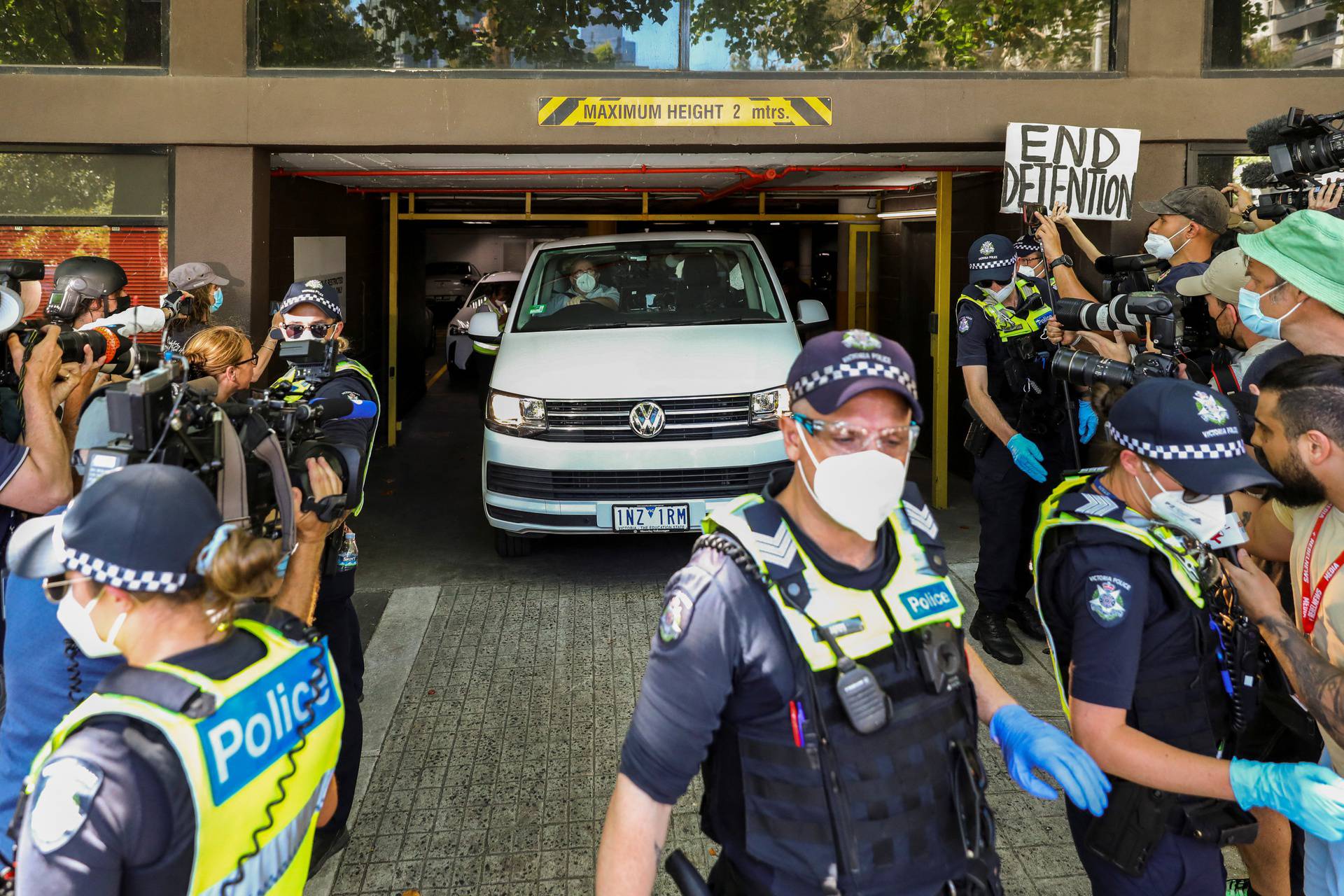 Media surround a vehicle at the facility where Novak Djokovic has been held in Melbourne