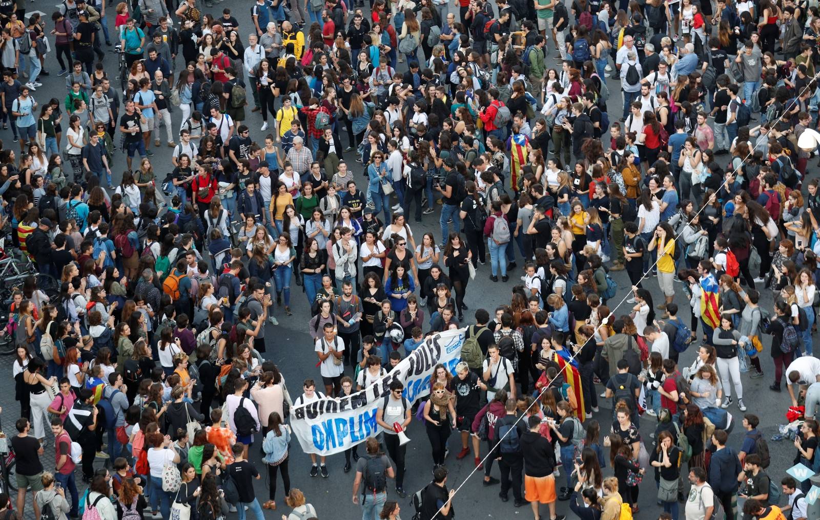 Students sit at Plaza Universidad after a verdict in a trial over a banned independence referendum, in Barcelona