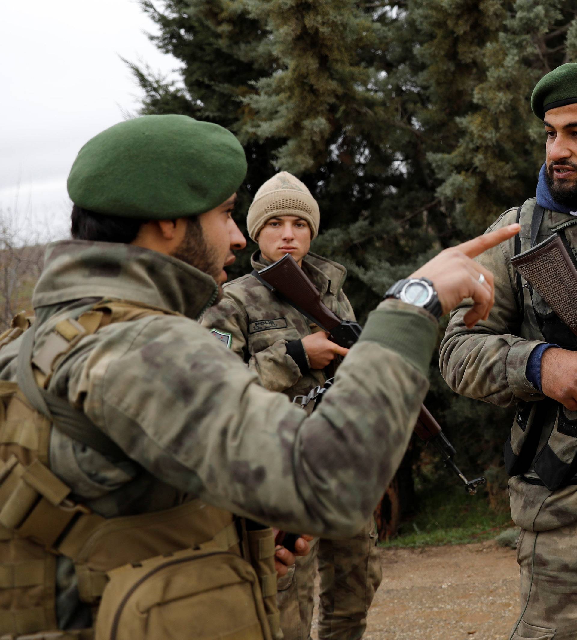 Members of Turkey-backed Free Syrian Army police forces secure the road as they escort a convoy near Azaz