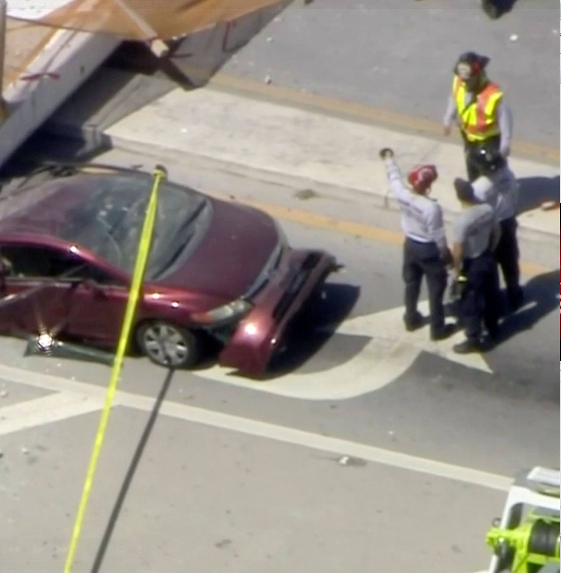 Emergency crews look for victims at the scene of a collapsed pedestrian bridge at Florida International University in Miami, Florida