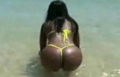 Tamnoputa djevojka trese svoju seksi guzu na plaži