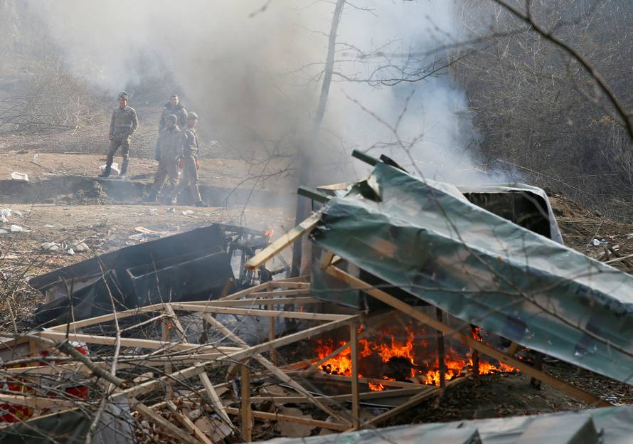 Ethnic Armenian soldiers stand next to a burning mock-up of a tank in the village of Knaravan