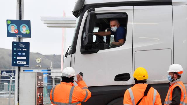 Lorry drivers show documentation as they arrive at Eurotunnel to travel to France, Folkestone, Britain