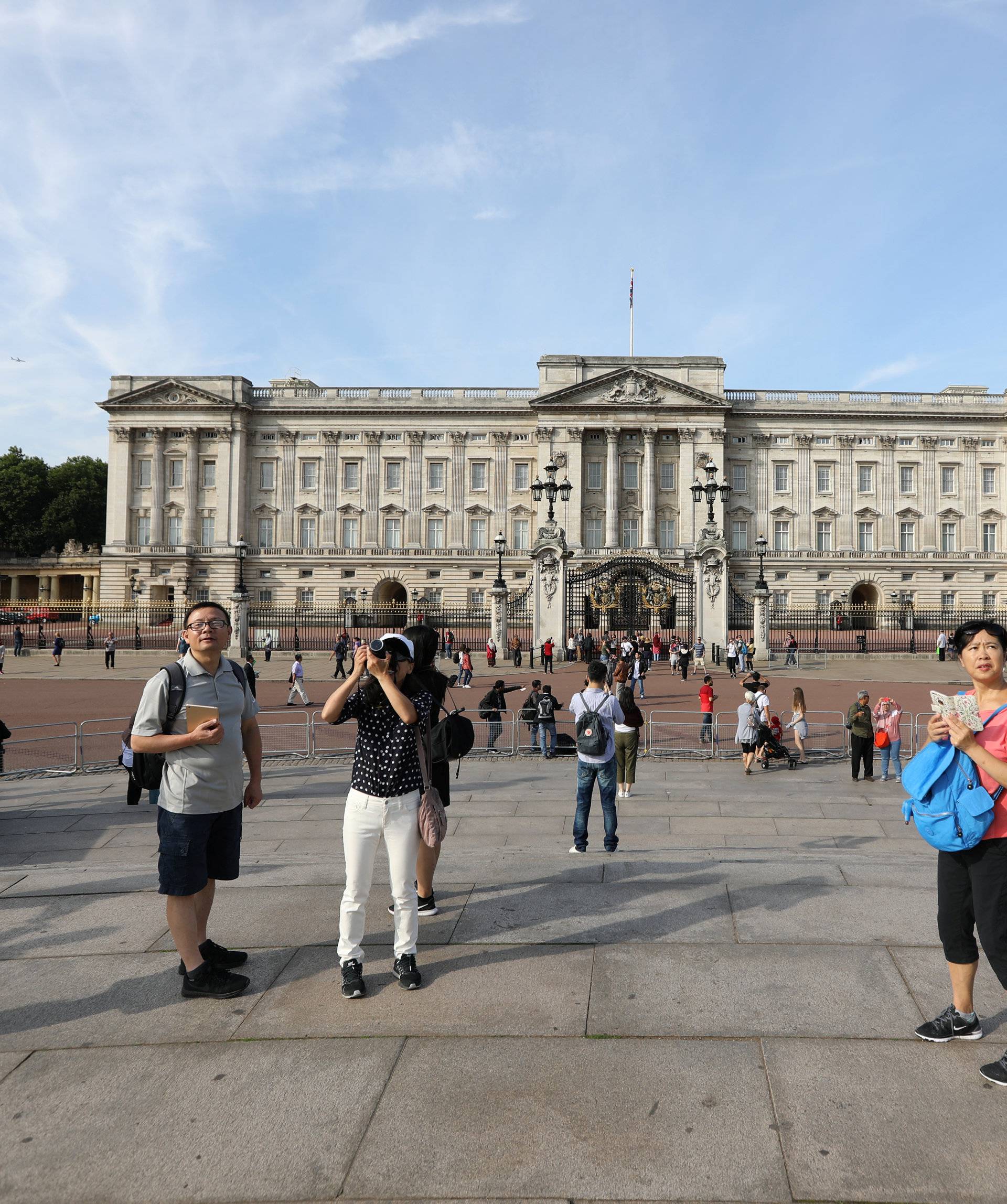 Tourists are seen outside Buckingham Palace in London