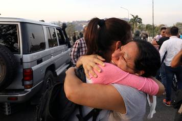 Opposition supporters hug near the Generalisimo Francisco de Miranda Airbase in Caracas