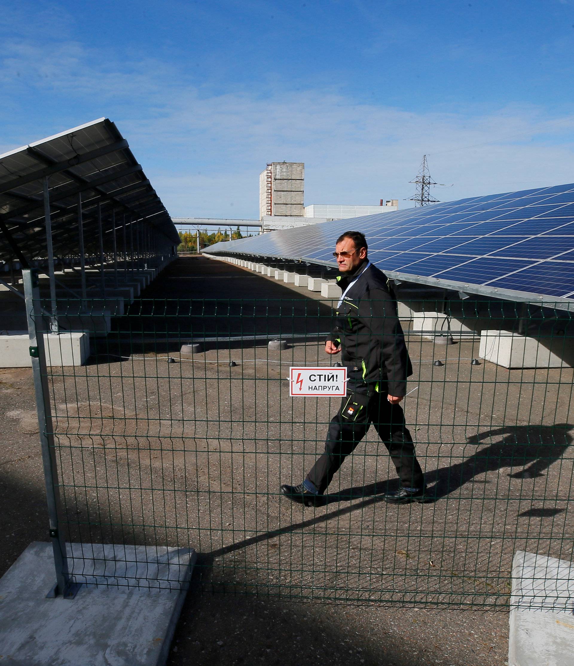 An employee walks past solar panels at a solar power plant built on the site of the world's worst nuclear disaster, Chernobyl