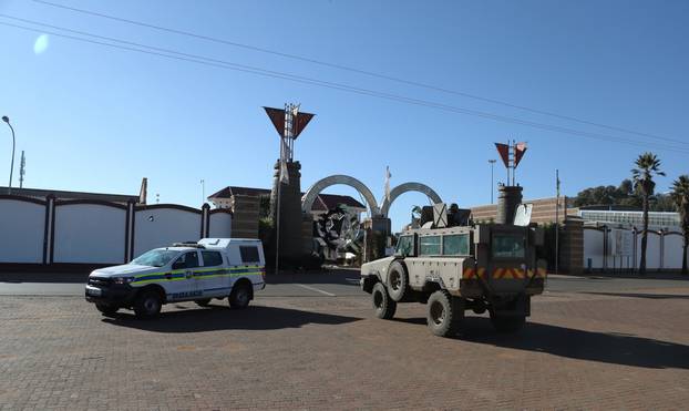 A police and a military vehicle are seen parked, as they keep watch outside a church