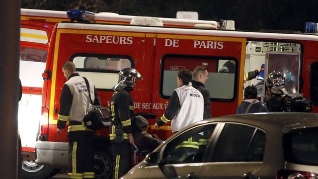  French firemen and doctors tend to a person who was one of six people in a travel agency when an armed man entered in what appears to be a robbery, according to a police source, in Paris