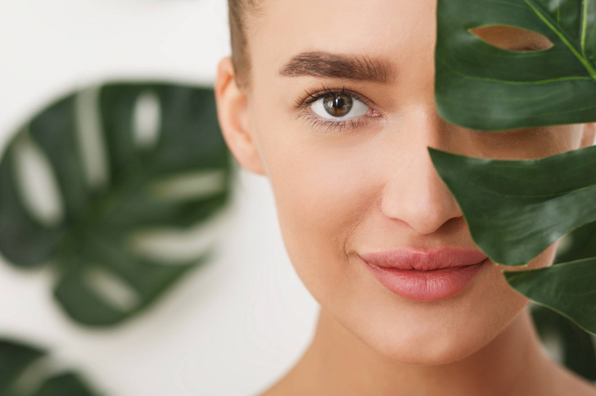 Woman with natural make up and green leaf