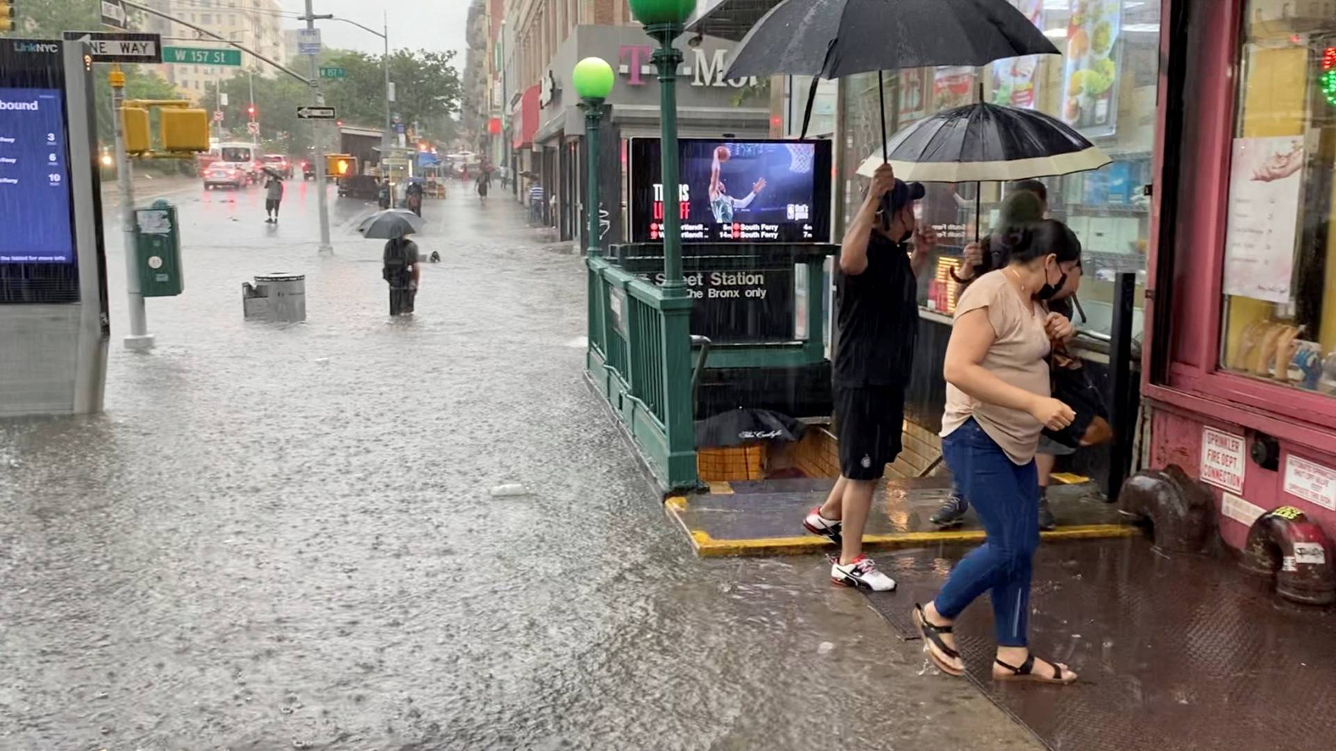 A person wades through the flood water near the 157th St. metro station in New York