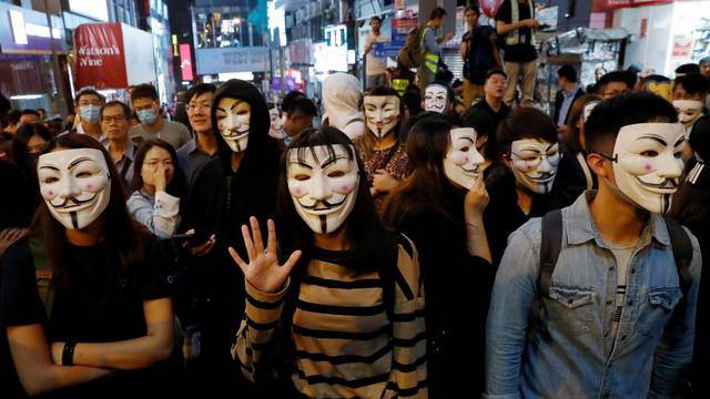 Anti-government protesters wear Guy Fawkes masks during a Halloween march in Lan Kwai Fong, Central district, Hong Kong