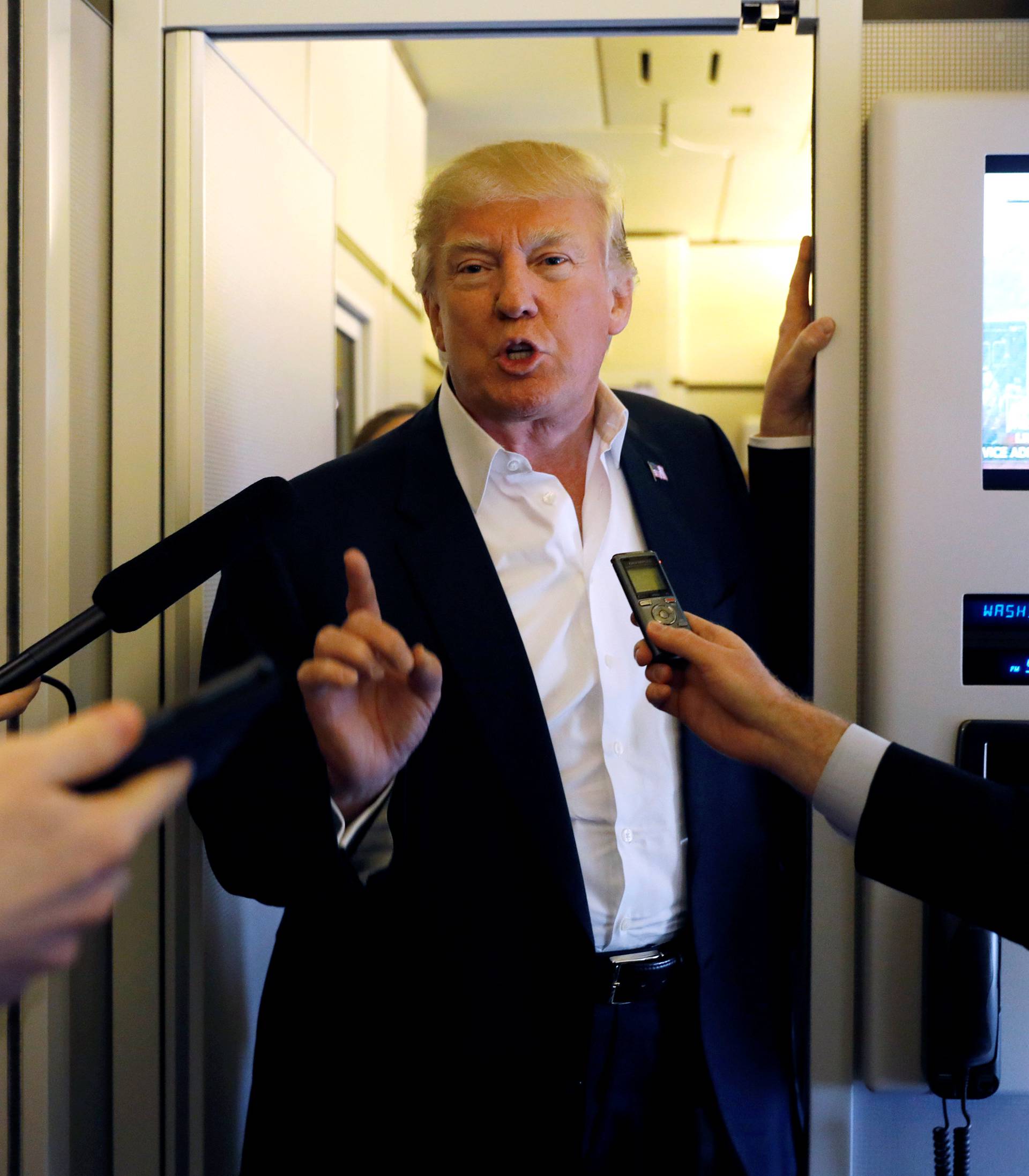 U.S. President Donald Trump speaks with reporters aboard Air Force One on his way to a "Make America Great Again" rally at Orlando Melbourne International Airport in Melbourne, Florida