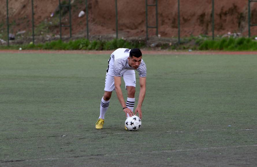 Biwar Abdullah, 25, an Iraqi Kurdish local footballer, who looks like the football player Cristiano Ronaldo, plays football at a football yard in the district of Soran, northeast of Erbil