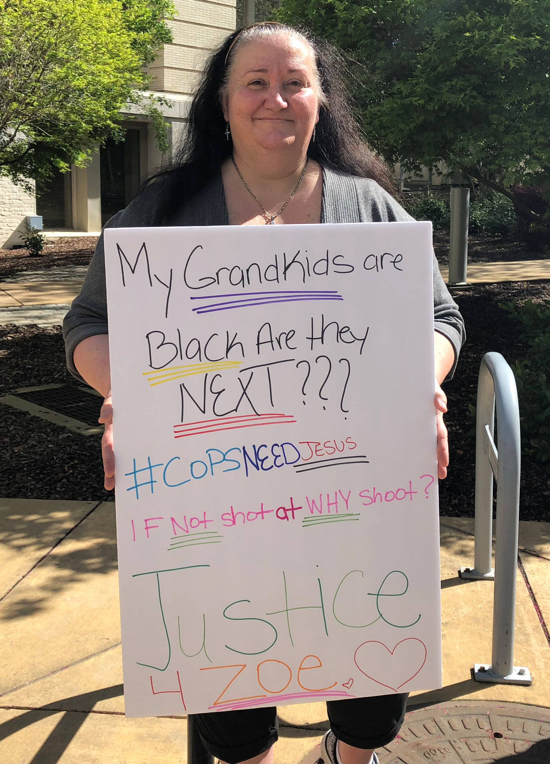 Tami Collins, shows a placard protesting the fatal shooting of Stephon Clark by Sacramento police, during a demonstration in Sacramento