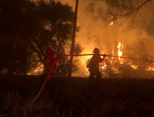 Firefighters work at the site of a wildfire in Goleta