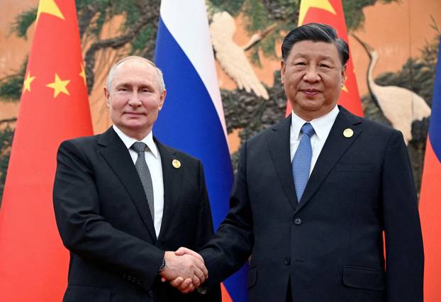 FILE PHOTO: Russian President Vladimir Putin shakes hands with Chinese President Xi Jinping