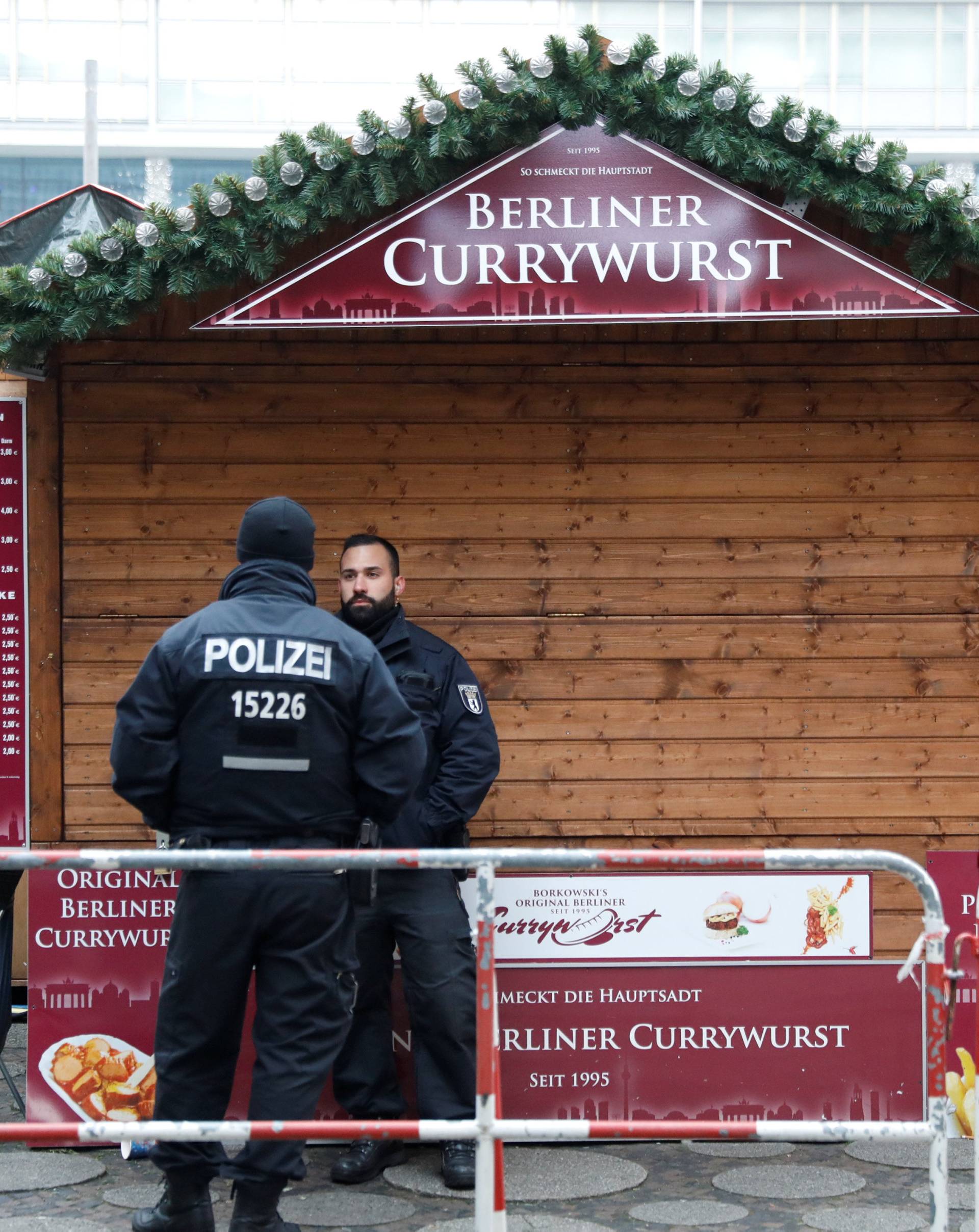 Policemen are seen near the area where a truck which ploughed into a crowded Christmas market in the German capital last night in Berlin