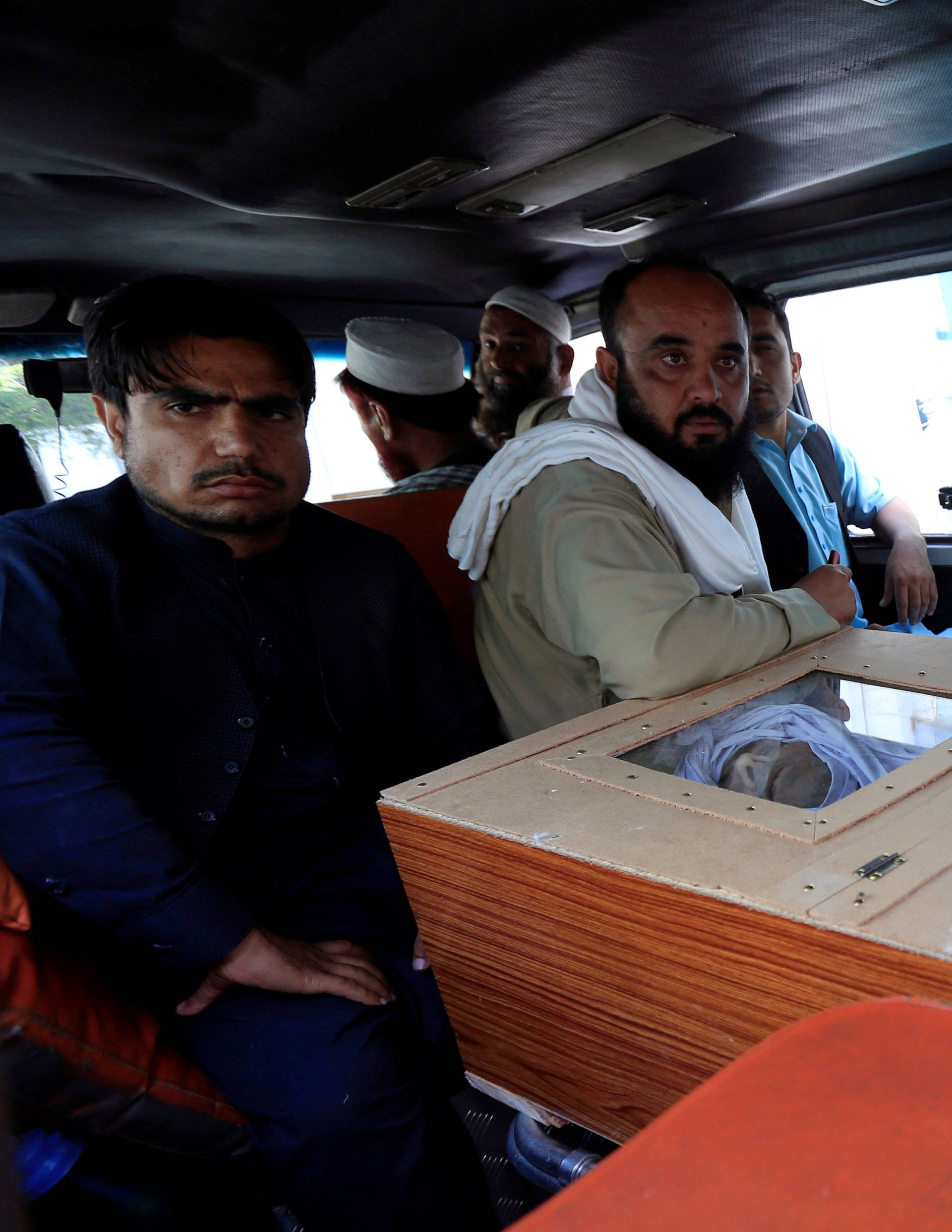 Men mourn over the coffin of a victim who was killed in blasts in Jalalabad city, Afghanistan