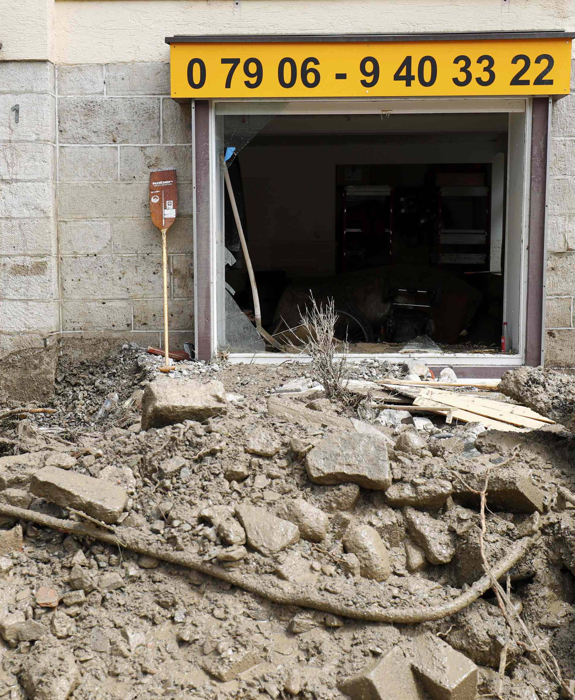 People look at the damage caused by the floods in the town of Braunsbach in Baden-Wuerttemberg