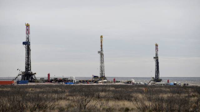 FILE PHOTO: Drilling rigs operate in the Permian Basin oil and natural gas production area in Lea County